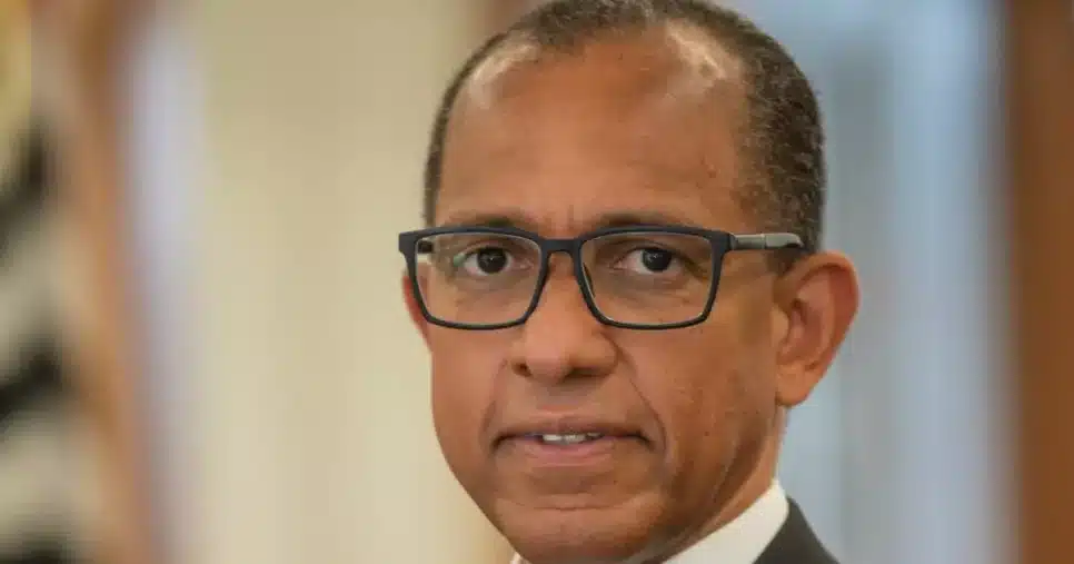 Homem de terno cinza escuro e camisa branca, usando óculos e posando com os braços cruzados. Ao fundo, ambiente interno desfocado. A imagem mostra Edilson Reis, diretor de TI do Grupo Bradesco Seguros.