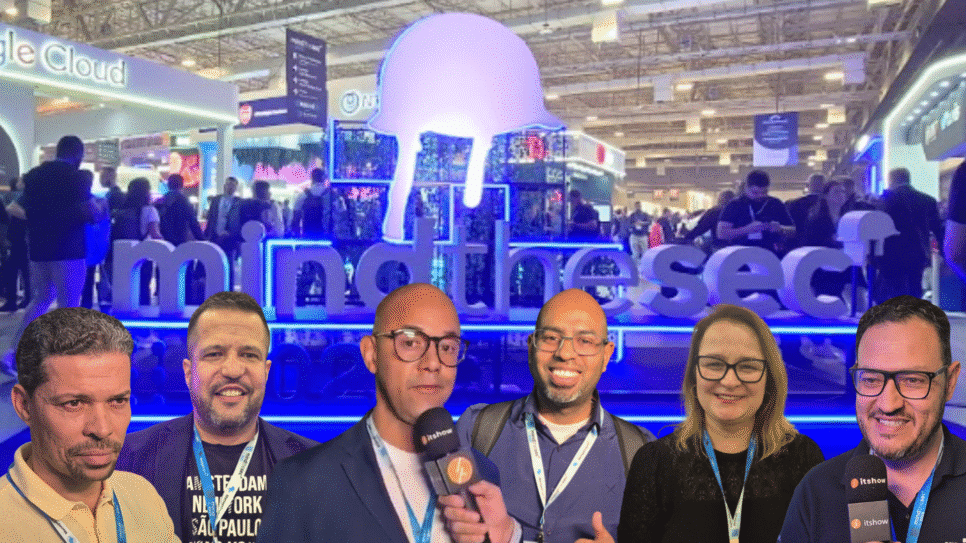 Mind The Sec: Estande iluminado “Mind The Sec” em evento de cibersegurança em São Paulo e entrevistados pelo Itshow em primeiro plano.