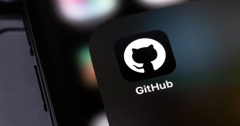 Logo do GitHub exibido na tela de um dispositivo móvel, com o icônico ícone de um gato em silhueta branca dentro de um círculo preto. O fundo desfocado destaca cores suaves, criando um ambiente tecnológico e minimalista, Github, Teki, Microsoft