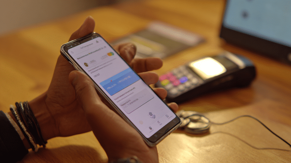 Usuário colombiano realiza pagamento digital por celular, representando o sistema de pagamento instantâneo Bre-B inspirado no Pix