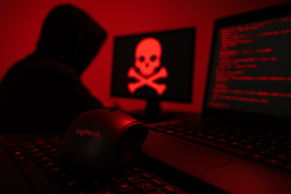 Imagem realista de um hacker em ambiente escuro com mouse Logitech em destaque, representando ataque cibernético e vazamento de dados da empresa.