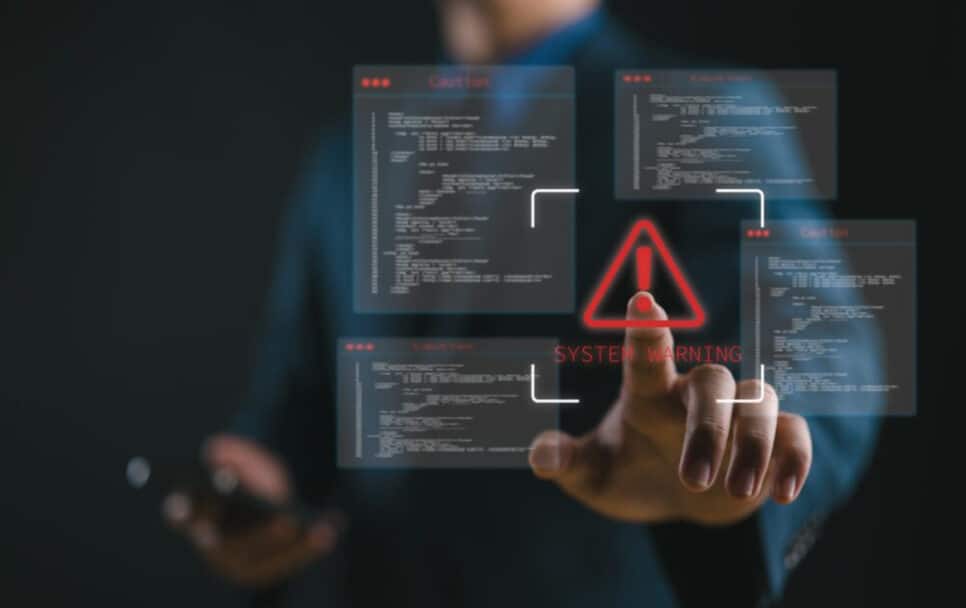 Imagem de um profissional interagindo com uma tela de aviso de sistema de segurança de computador, destacando um alerta com ícone de aviso e código de programação, setor, Kaspersky, violações