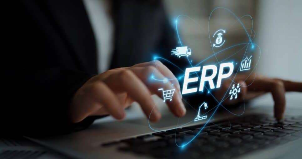 Pessoa digitando em um laptop, com a palavra “ERP” em destaque sobreposta à imagem, cercada por ícones digitais que representam logística, finanças, compras, produção e gestão de dados. Representação do uso de sistemas ERP na administração empresarial.